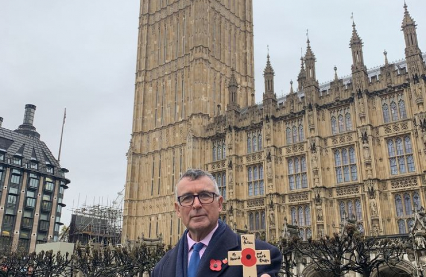 Bernard holding a cross with a poppy on it ready to plant in remembrance 
